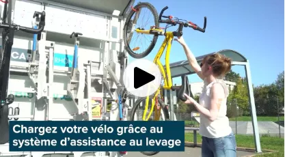 personne mettant un velo sur l'emport vélo derrière un car